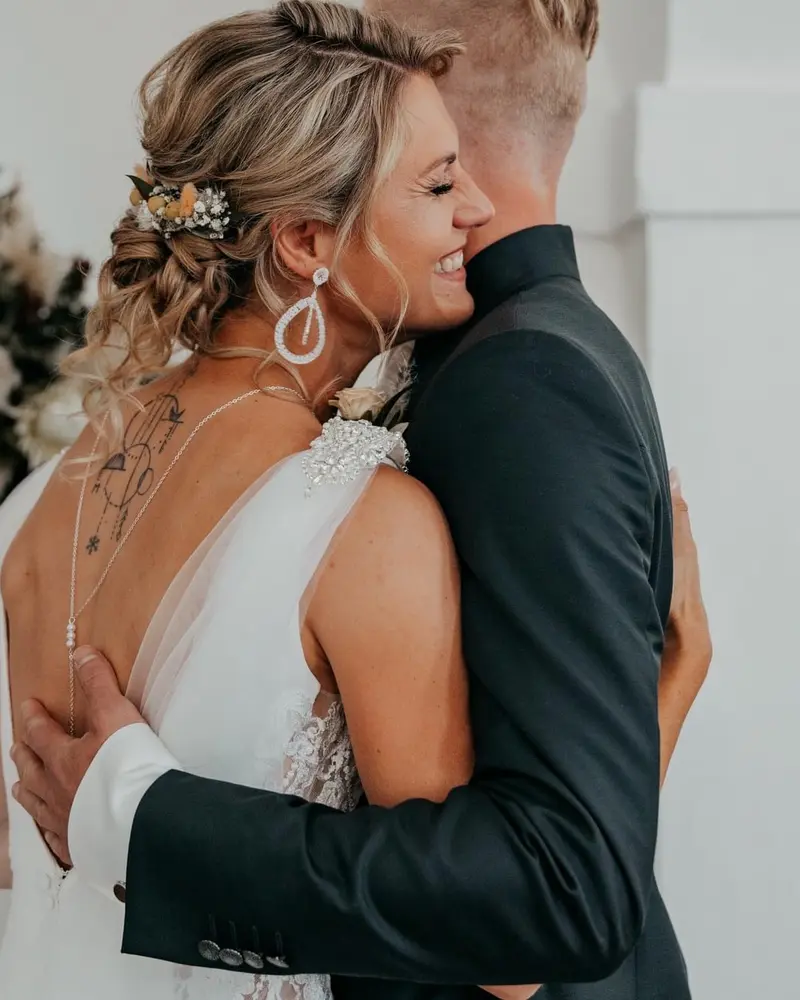 Brautpaar bei der Umarmung mit Blumenschmuck im Haar